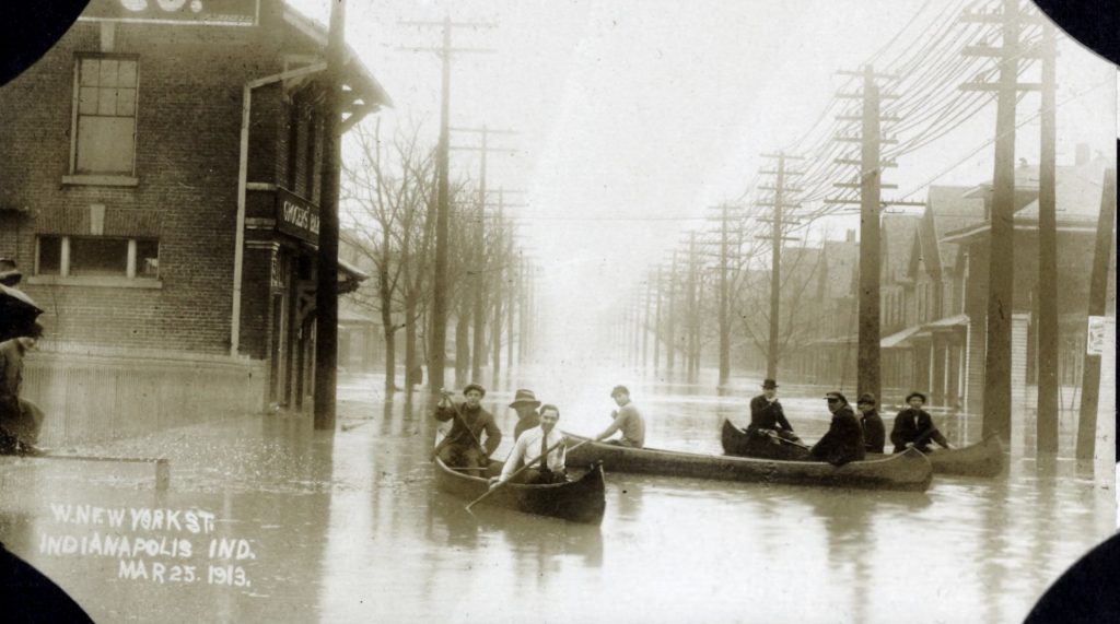 Residents canoe down a flooded street.