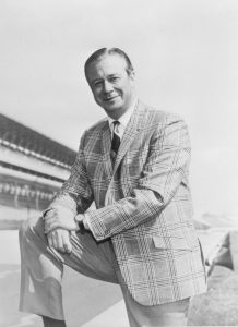 A man poses on a race track.