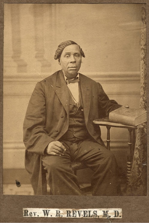 Portrait of Rev. Willis R. Revels sitting in a chair.