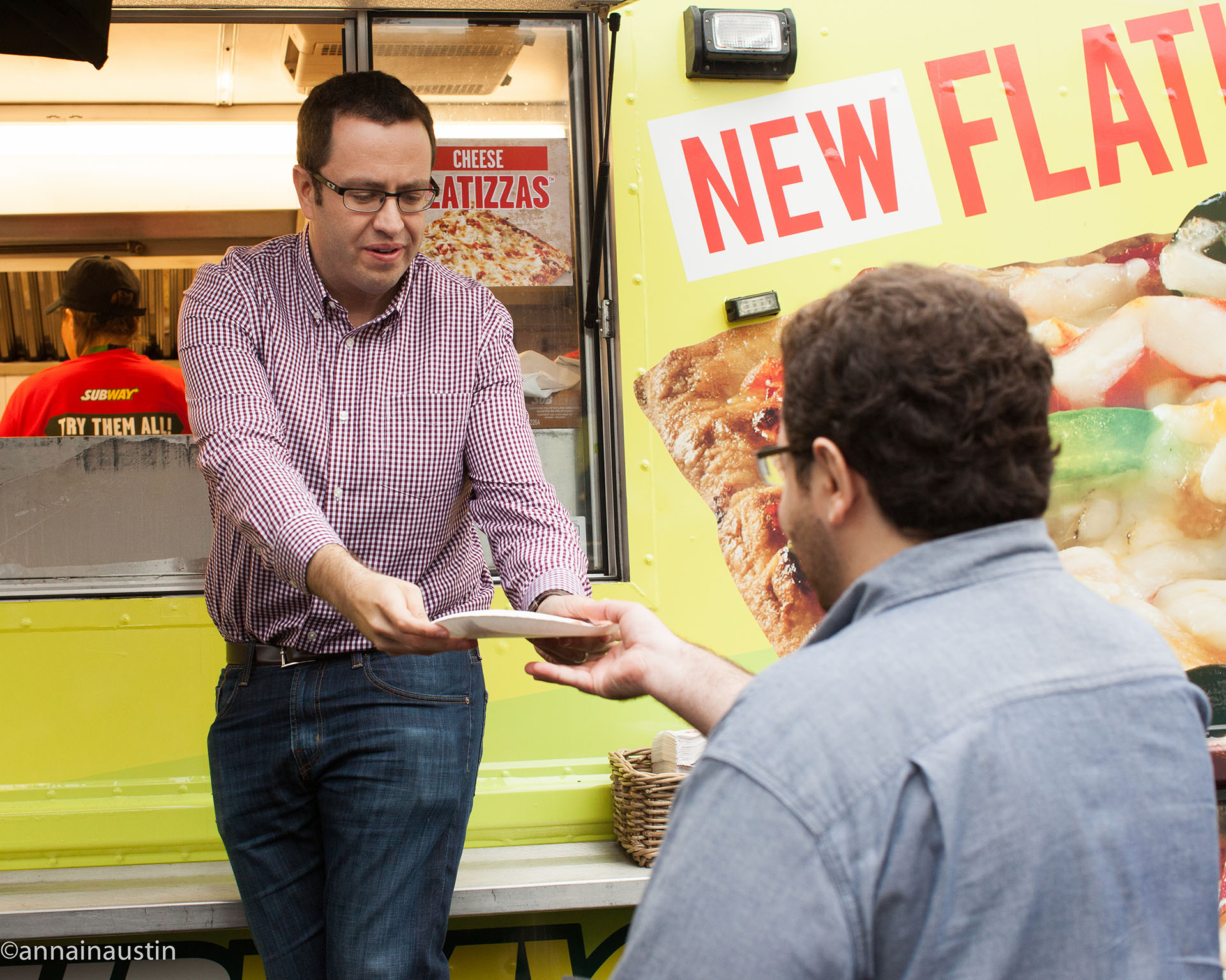 Jared Fogle passes a plate of food to a customer.