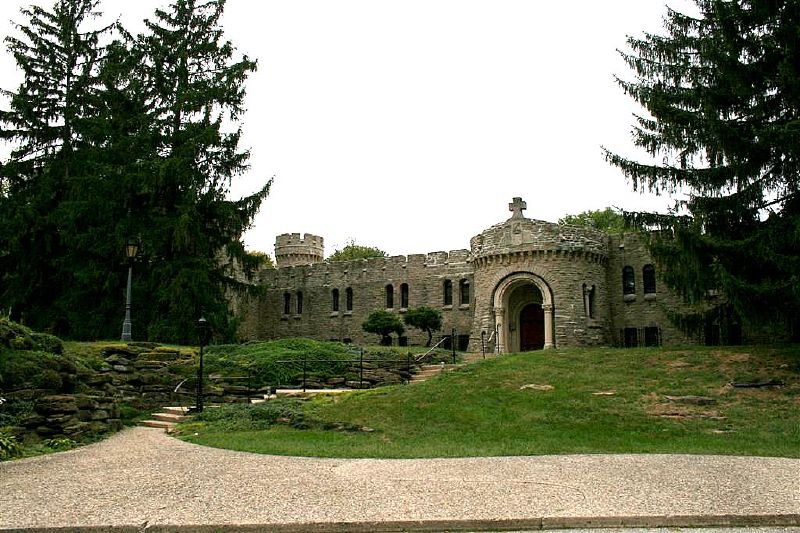 A path leads up to a stone building with an arched entryway.