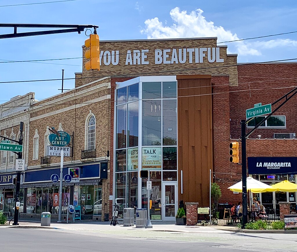 Corner of a business building. The phrase "You are beautiful" is painted on the top of the building. 