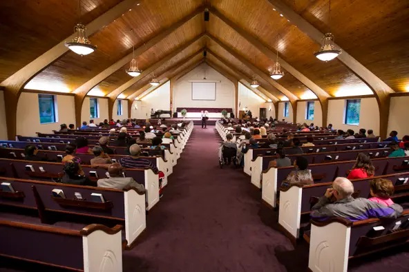 Chapel of the Glendale Seventh-Day Adventist Church with people sitting in the pews listening to a service.