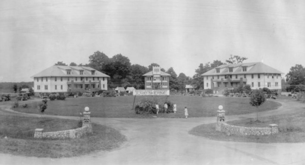 Panoramic view of a drive way leading to three separate multi-story buildings. 