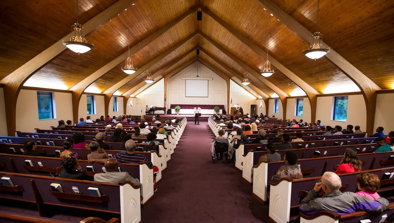 Chapel of the Glendale Seventh-Day Adventist Church with people sitting in the pews listening to a service.