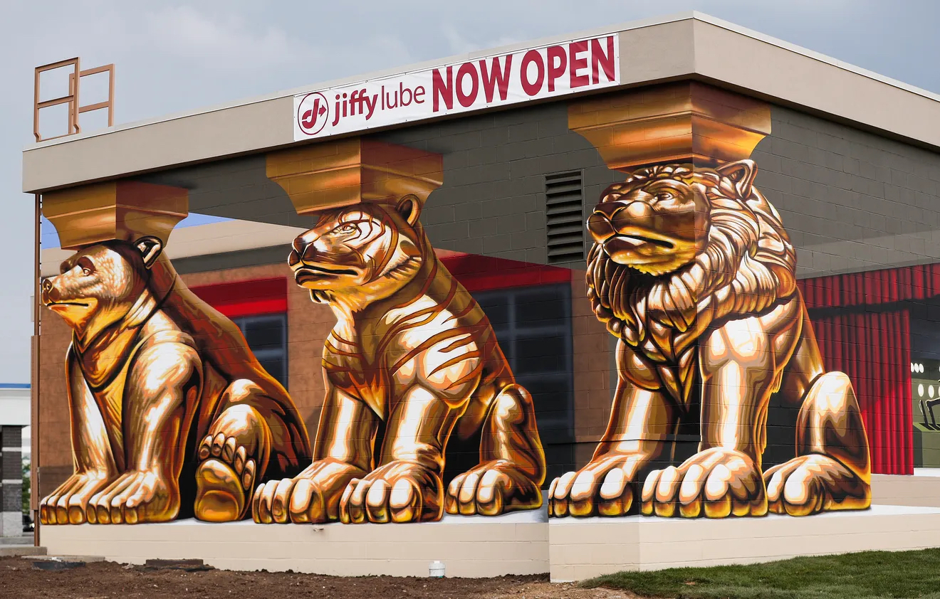 A mural that shows golden statues of a bear, tiger, and lion.