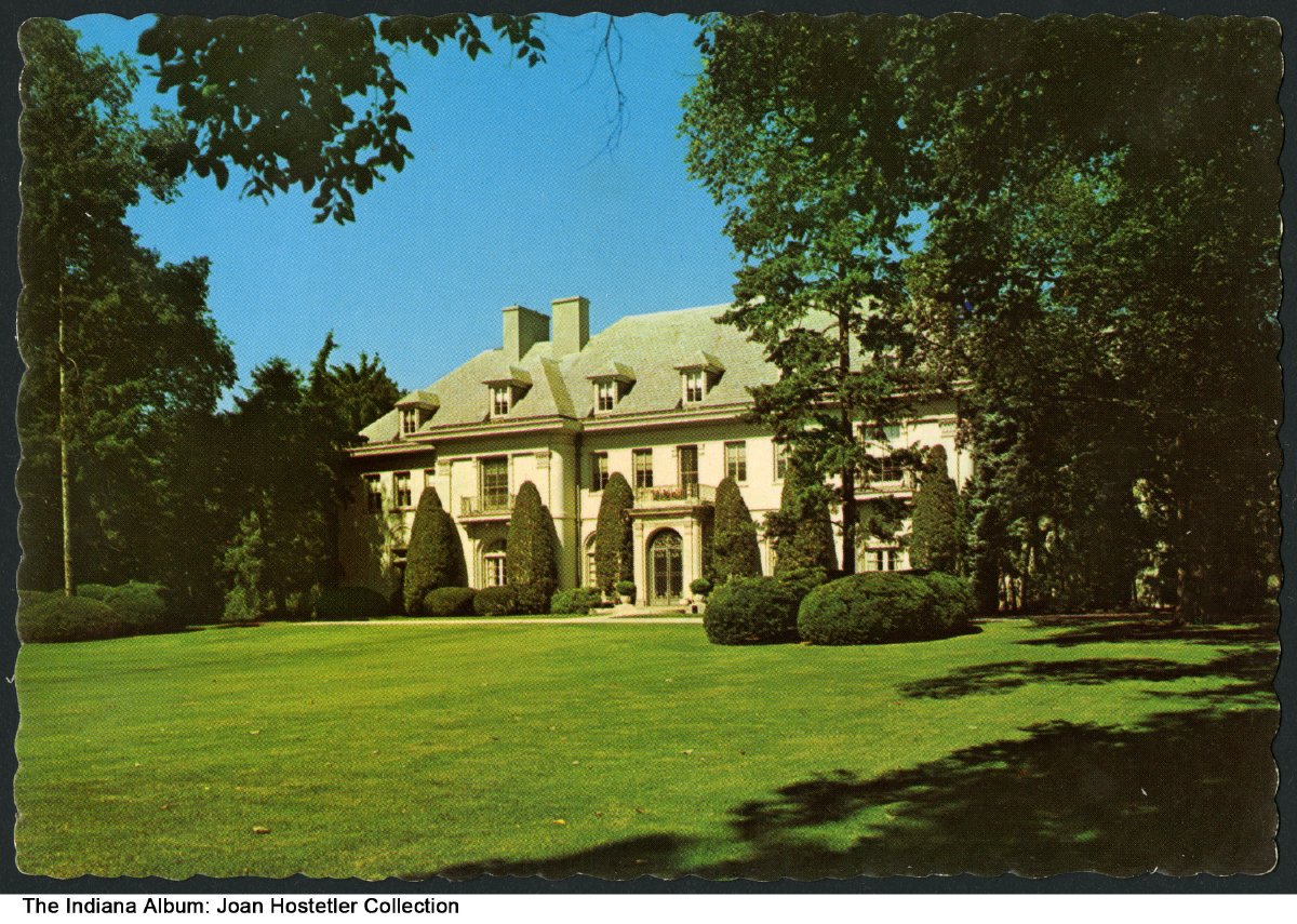 A multi-story mansion set among trees.