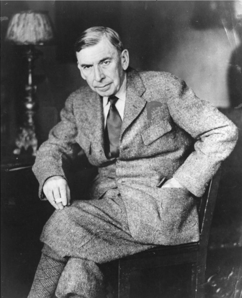 Booth Tarkington sits in a chair with a lit cigarette in his hand.