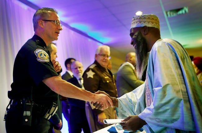 Two men shake hands.