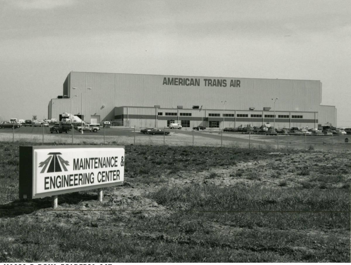 A large industrial building with American Trans Air on the front of it. A sign on the grounds reads "Maintenance Engineering Center."