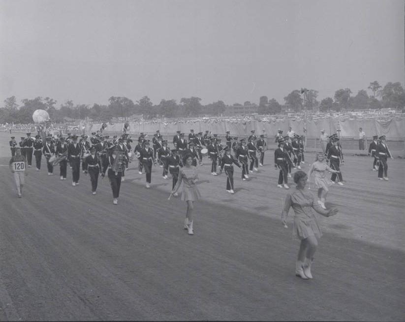 A marching band walking in formation down a street. 