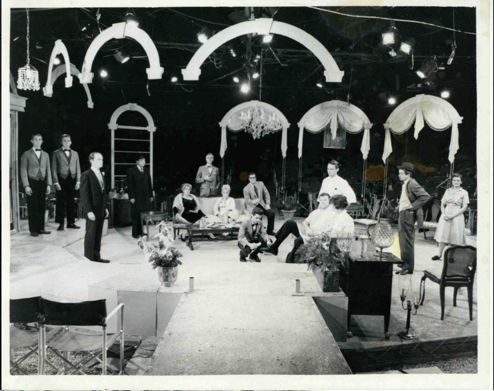 Several people, furniture and props are shown on a stage.