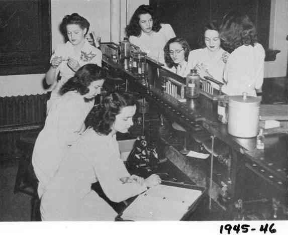 A group of women work together at a lab bench.