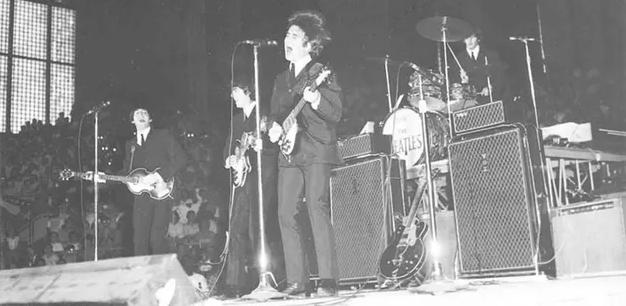 The Beatles are performing on stage.