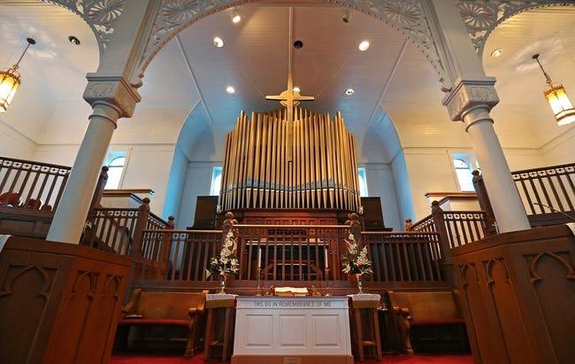 A view of a church sanctuary with an organ placed centrally.