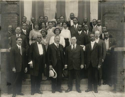 A group of Black leaders stand on the steps of a building.