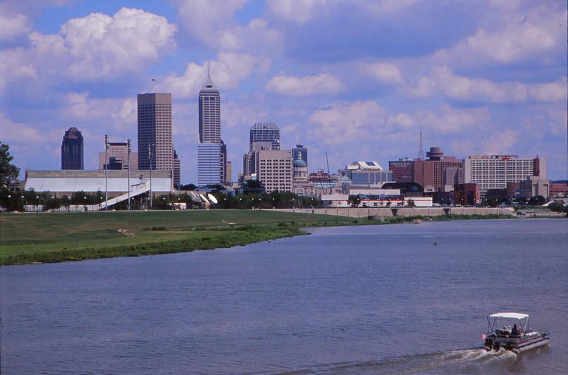 A river is in the foreground with a boat. The city skyline is in the background.