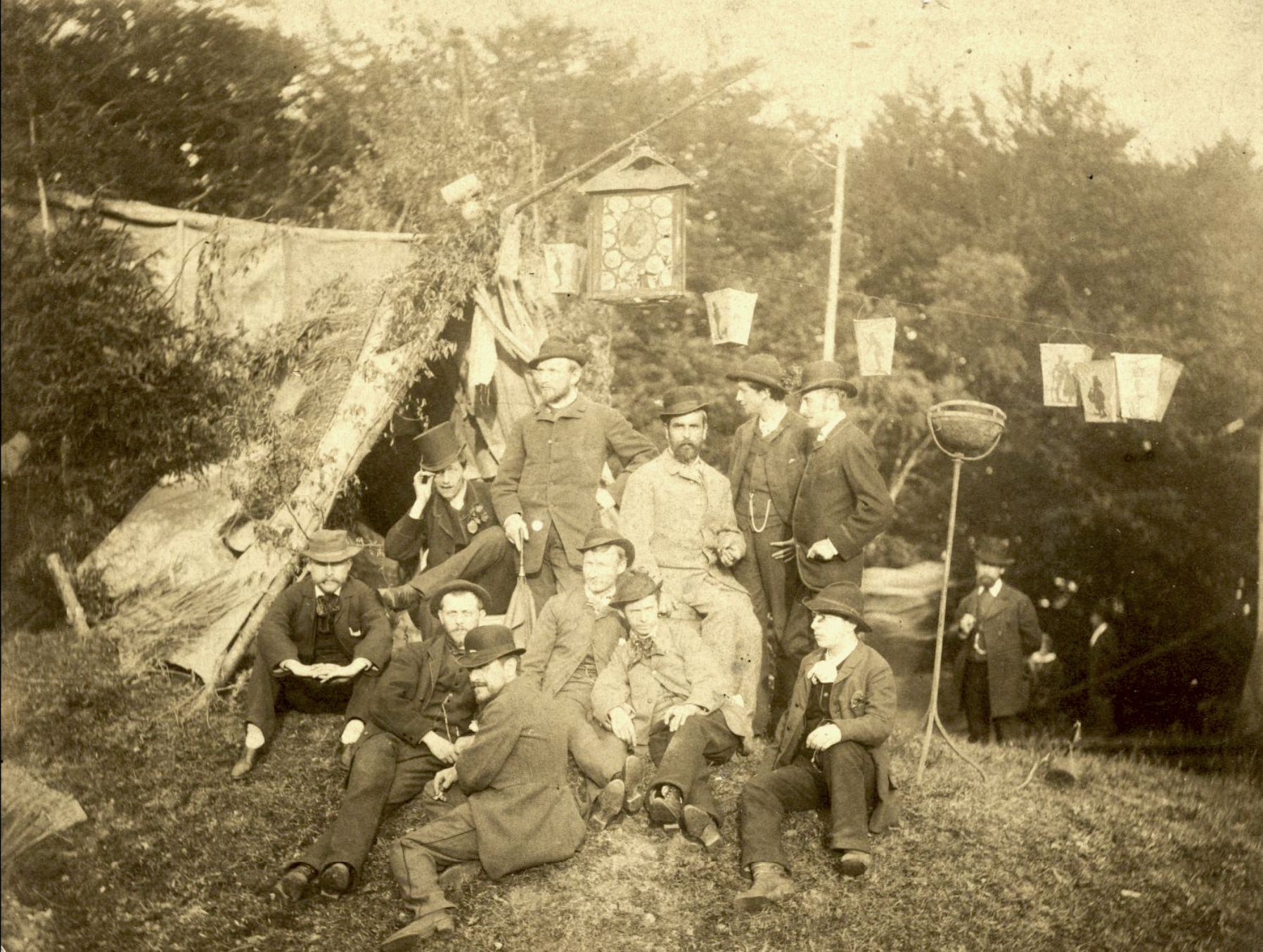 A group of young men pose together outside of a tent.