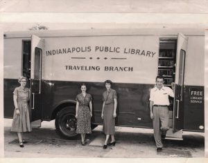 Indianapolis Public Library Traveling Branch bus with four staff members, ca. 1950s