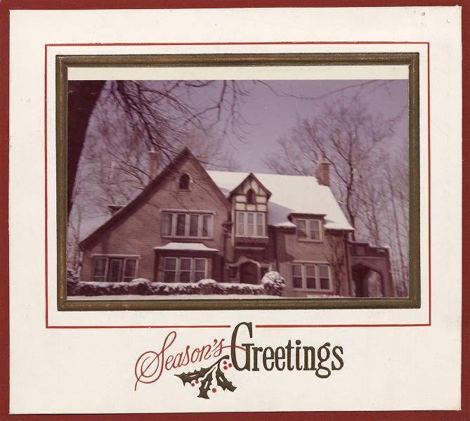 A holiday card shows a brick, Tudor-style house with snow on the roof. At the bottom "Season's Greetings" is written.