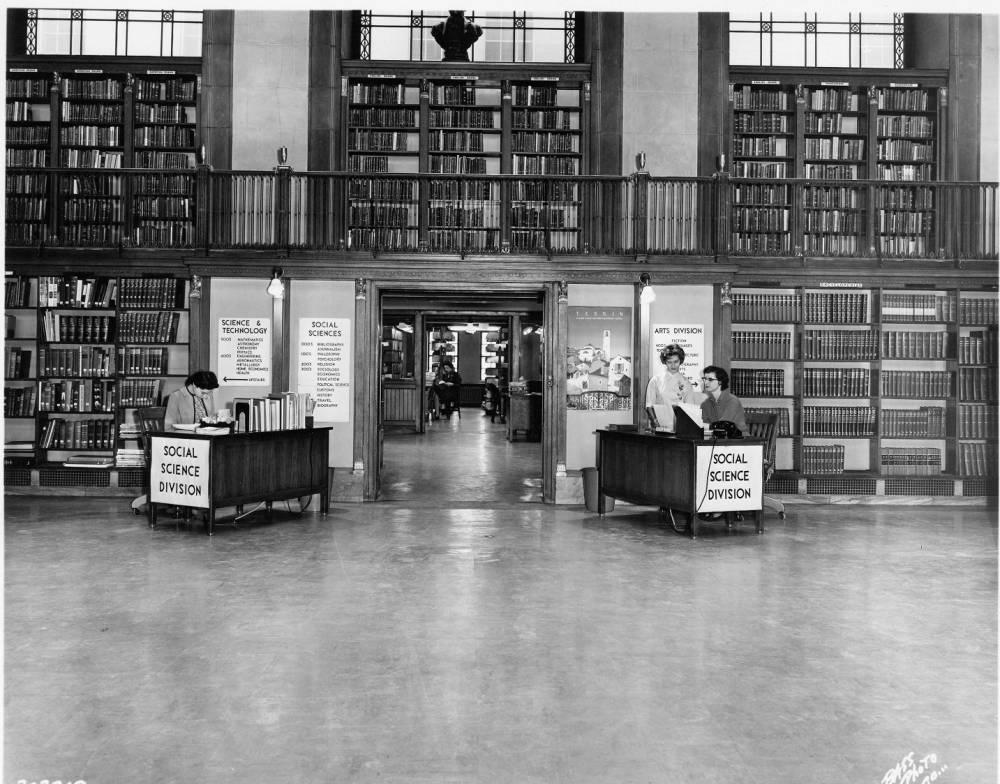 A desk is set up on either side of an entryway. Signs on both desks reads "social science division."