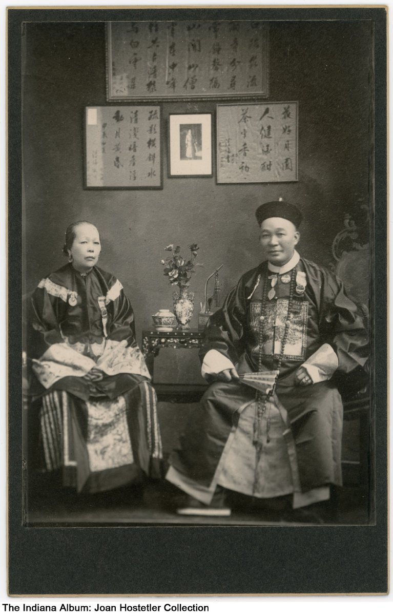 A man and a woman sit on either side of a small table.