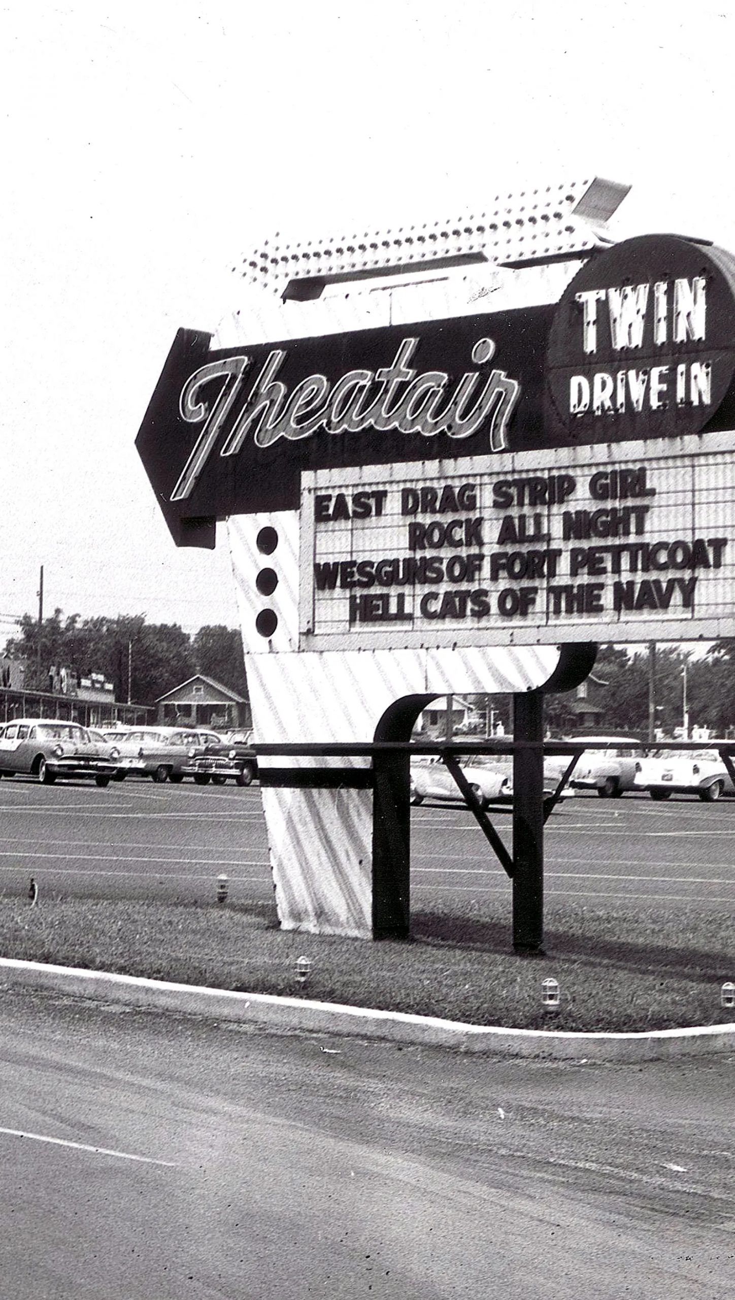 A large, freestanding marquee sign reads "Theatair Twin Drive In" and lists the names of the movies currently showing.
