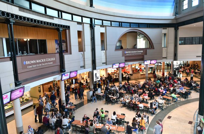 Upper-level view of many people in a large, open atrium.