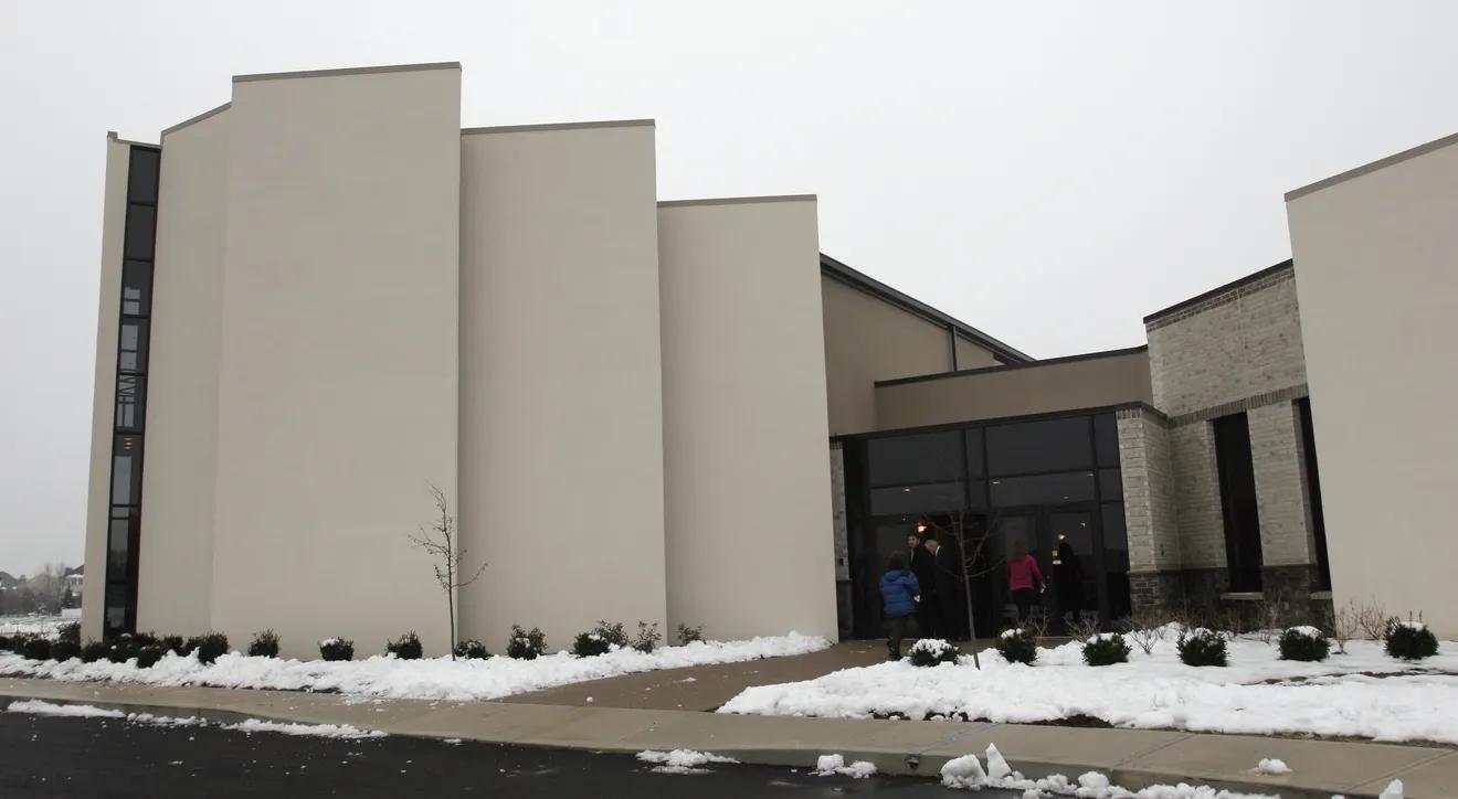 Exterior view of a modern religious building with simple panels making up the exterior. .