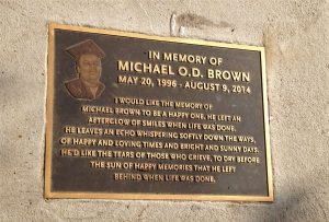 Plaque of Michael Brown in Ferguson, Missouri on sidewalk where shooting incident occurred.