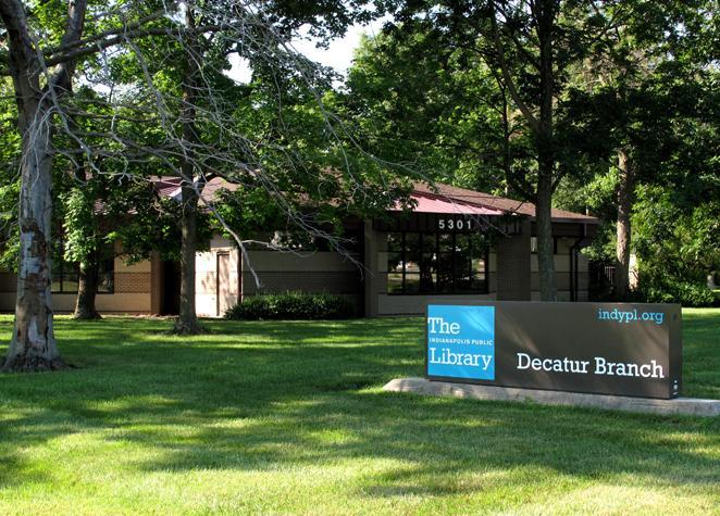 Exterior view of a building with a large sign on the lawn that reads "Decatur Branch."