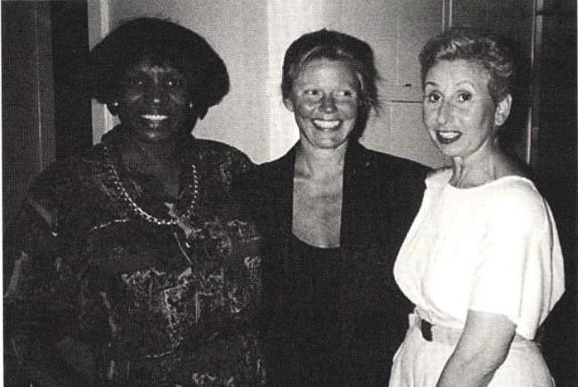 Three women stand together.
