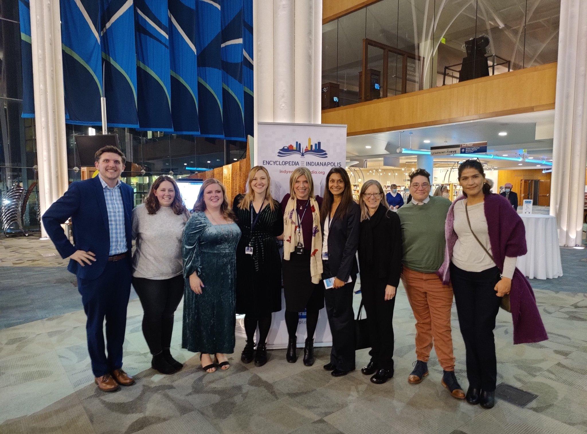 A group of people pose together in a large atrium.