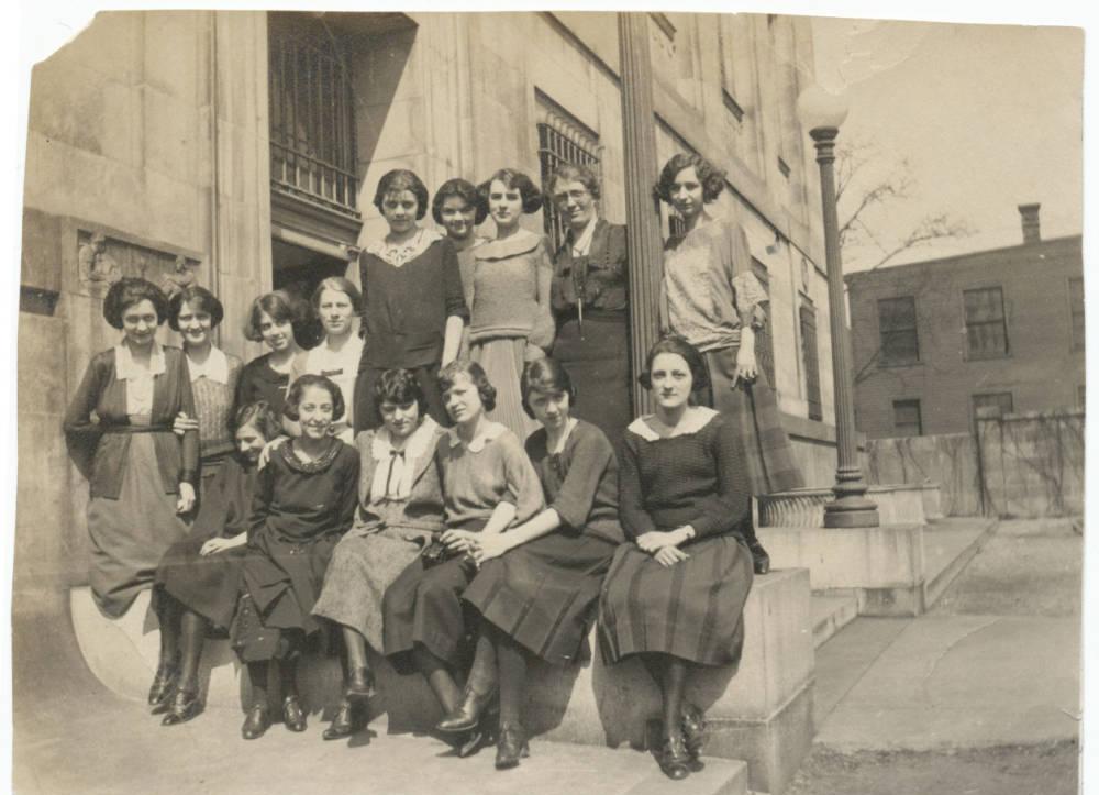 A group of women stand together outside of a building.
