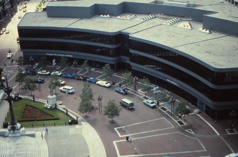 An aerial view of a large multistory building that curves to follow the circular-shaped street.