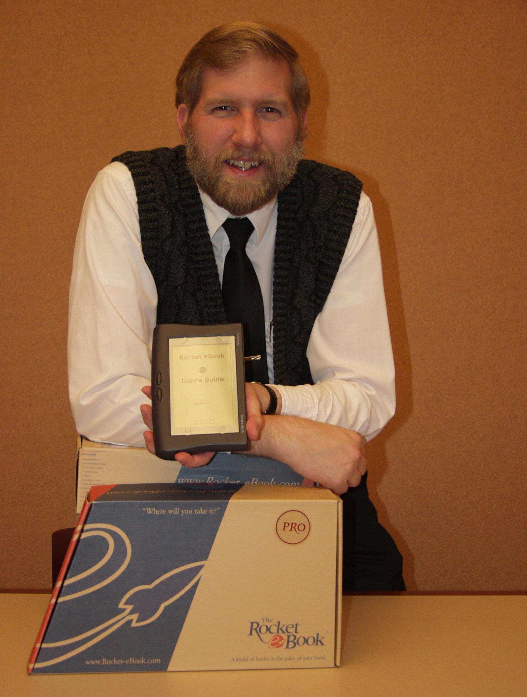 A man holds up an ereader.