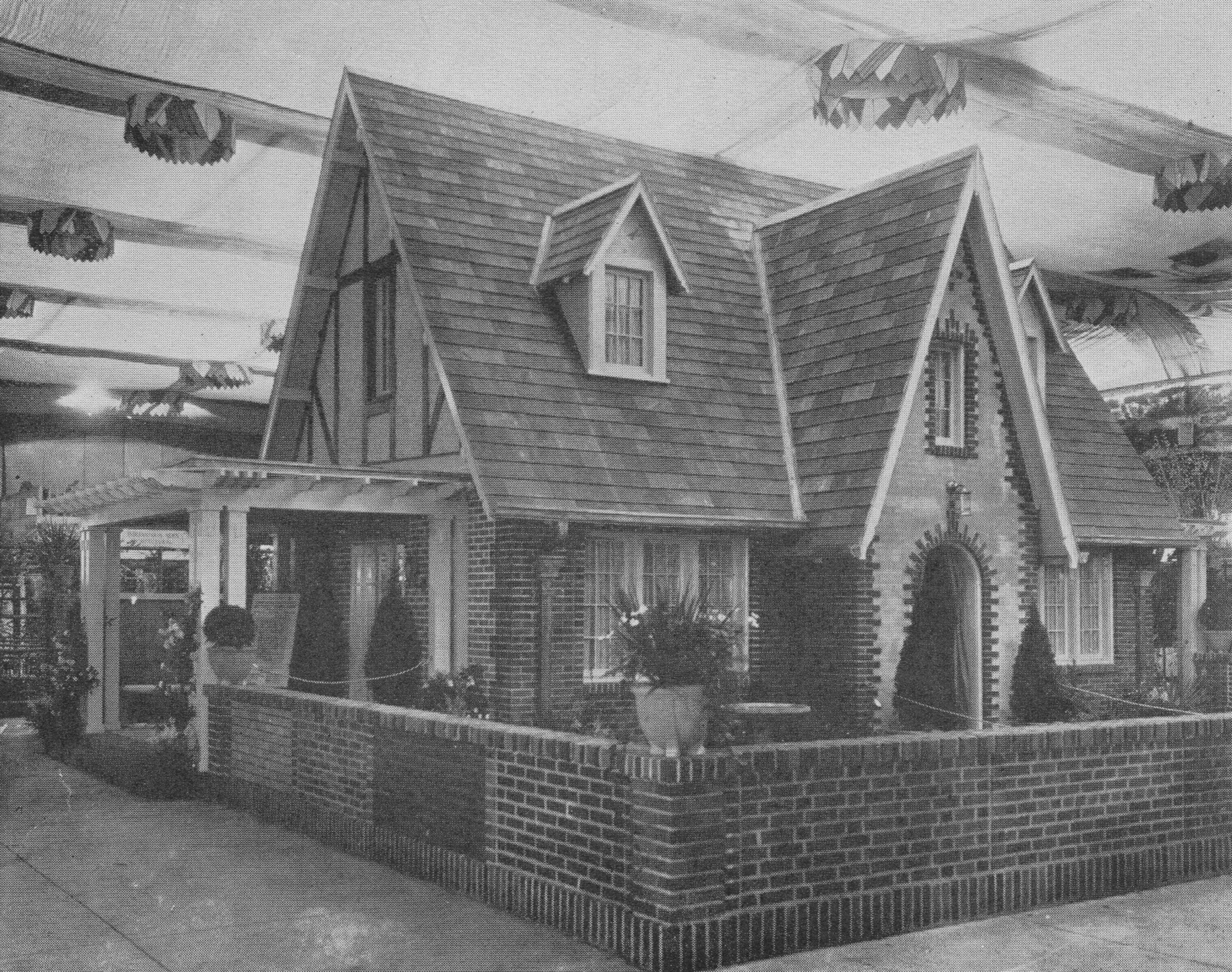 A small single-story house in the middle of an expo hall. 