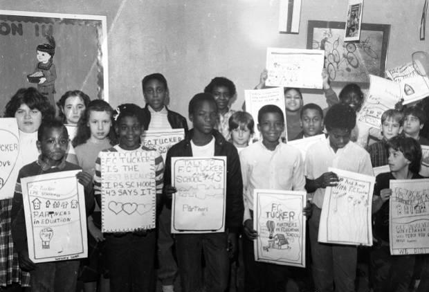 A group of children holds handmade posters.