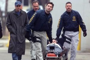 Greg Dixon on a stretcher being wheeled out of Indianapolis Baptist Temple by U.S. Marshals, 2001