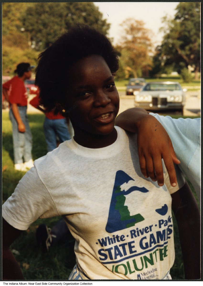 A woman wears a t-shirt with the White River games logo on it.