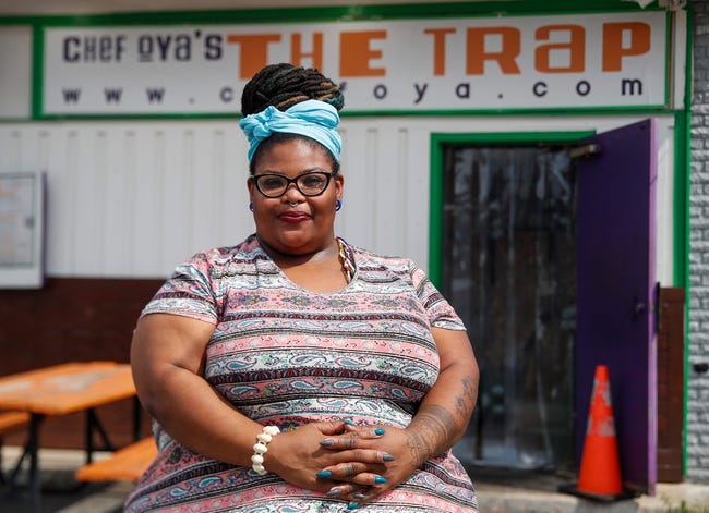 Oya Woodruff sits on a bench outside of her restaurant.