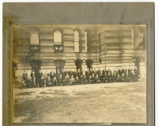 A group of people stand outside a building.