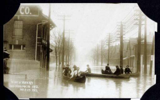 Residents canoe down a flooded street.