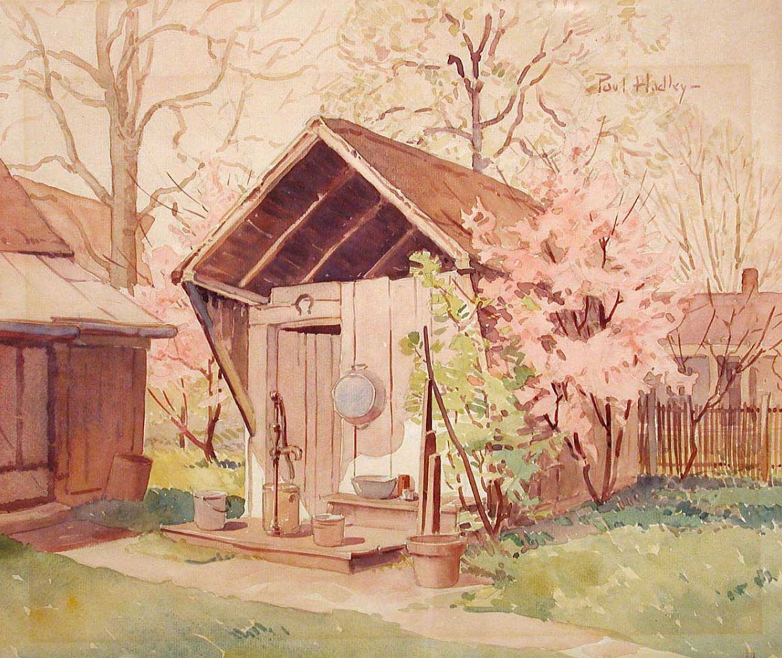 A wooden shed sits in a yard. There is a water pump in front of the door and various pots and pans around the entrance.