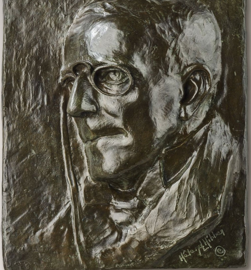 A bronze relief showing a man's face. 