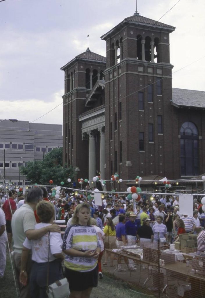 The Italian Renaissance building features twin bell towers on either side of the entrance. The entrance has a gable roof over a pedimented, columned portico.