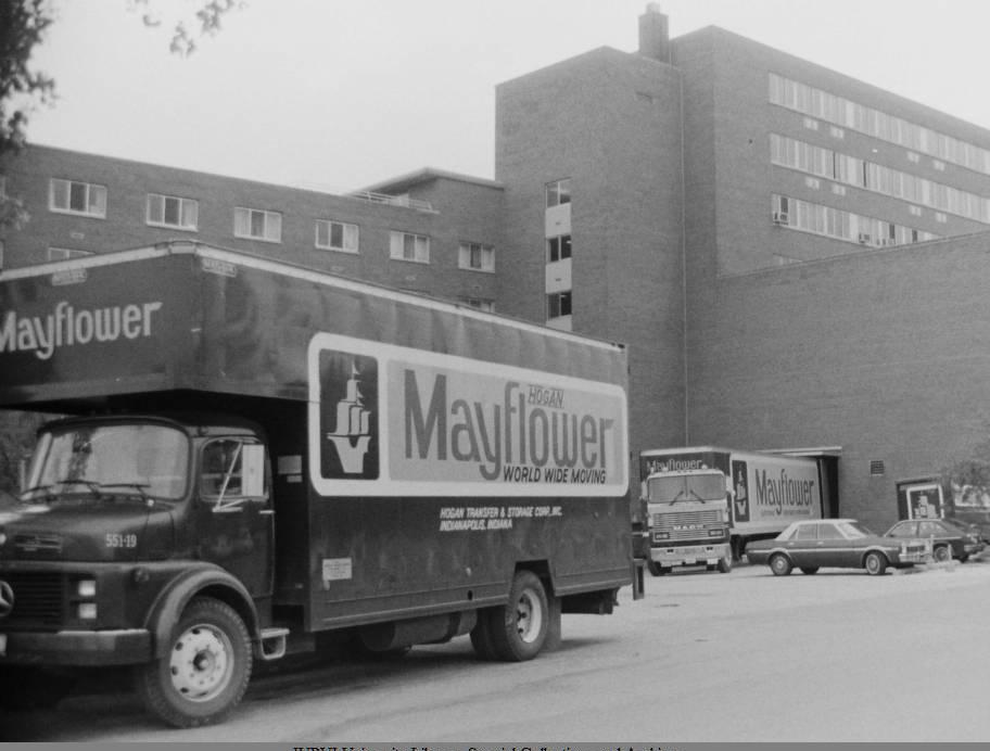 A moving van is parked in front of a building.