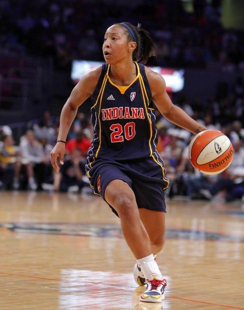 A basketball player dribbles a ball on the basketball court.