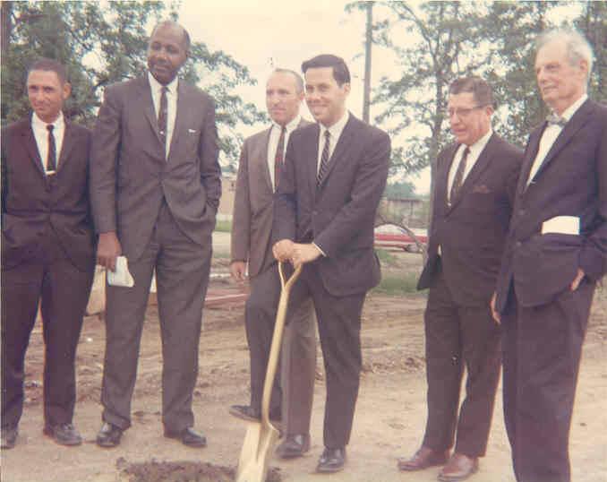 Mayor Richard G. Lugar holds a shovel. Several other men are standing next to him.
