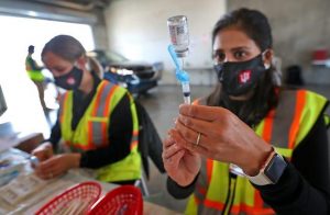 Pharmacist Punam Lively, right, and Christy Kaminski, RN, left, get shots ready in the garages for people to get vaccinated at the Indianapolis Motor Speedway, 2021